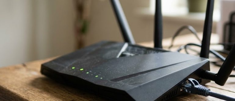 Wi-Fi роутер с горящими индикаторами на рабочем столе