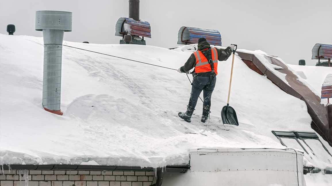 очистка снега с крыш альпинистами
